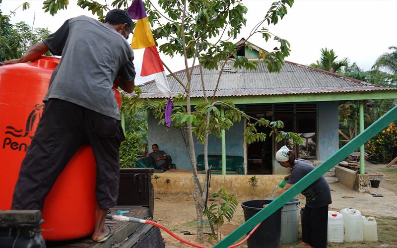 (Nenek Suratin saat menampung air bersih. Tandon air, diangkut mobil pickup, air bersih didistribusikan ke masyarakat Desa Kembang Ayun)