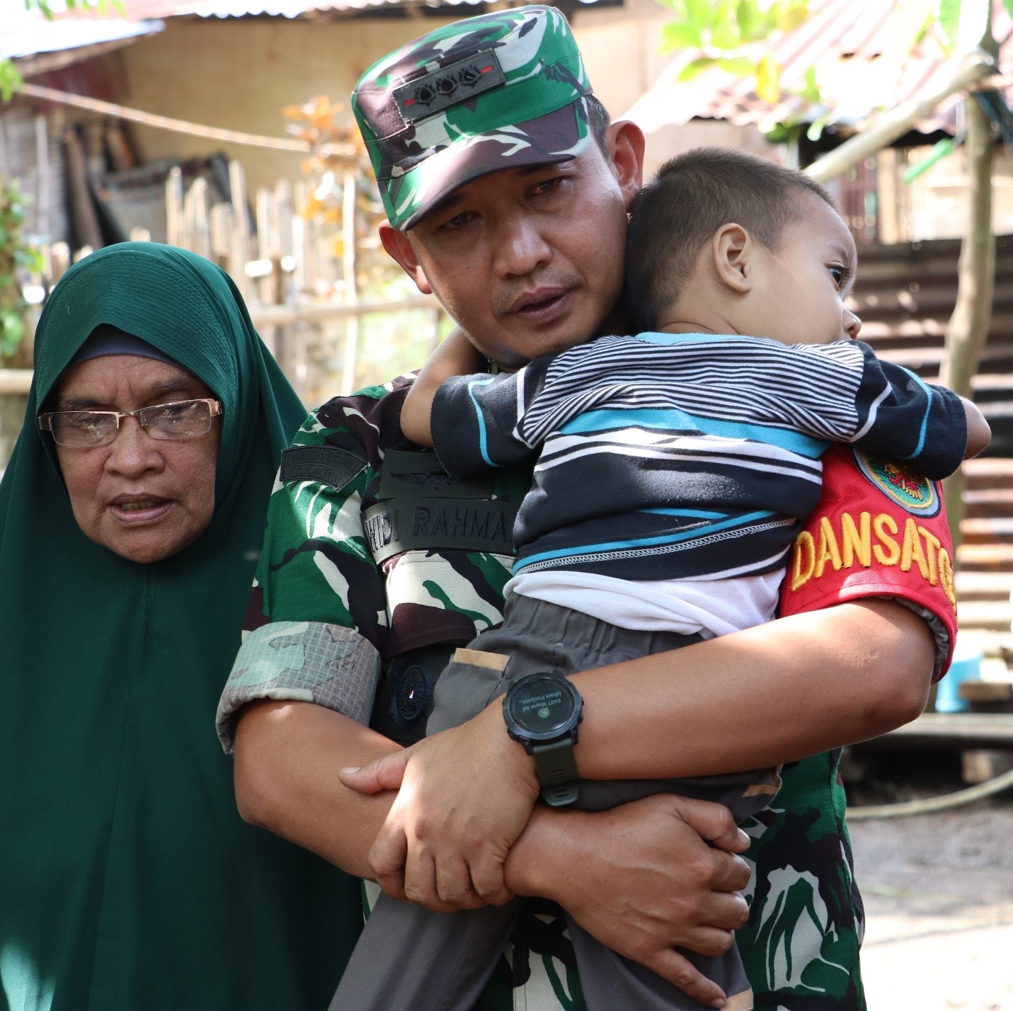 Menyiratkan keprihatanannya, Dansatgas Kolonel Inf Widi menggendong buah hati pasutri penerima rehab RTLH.