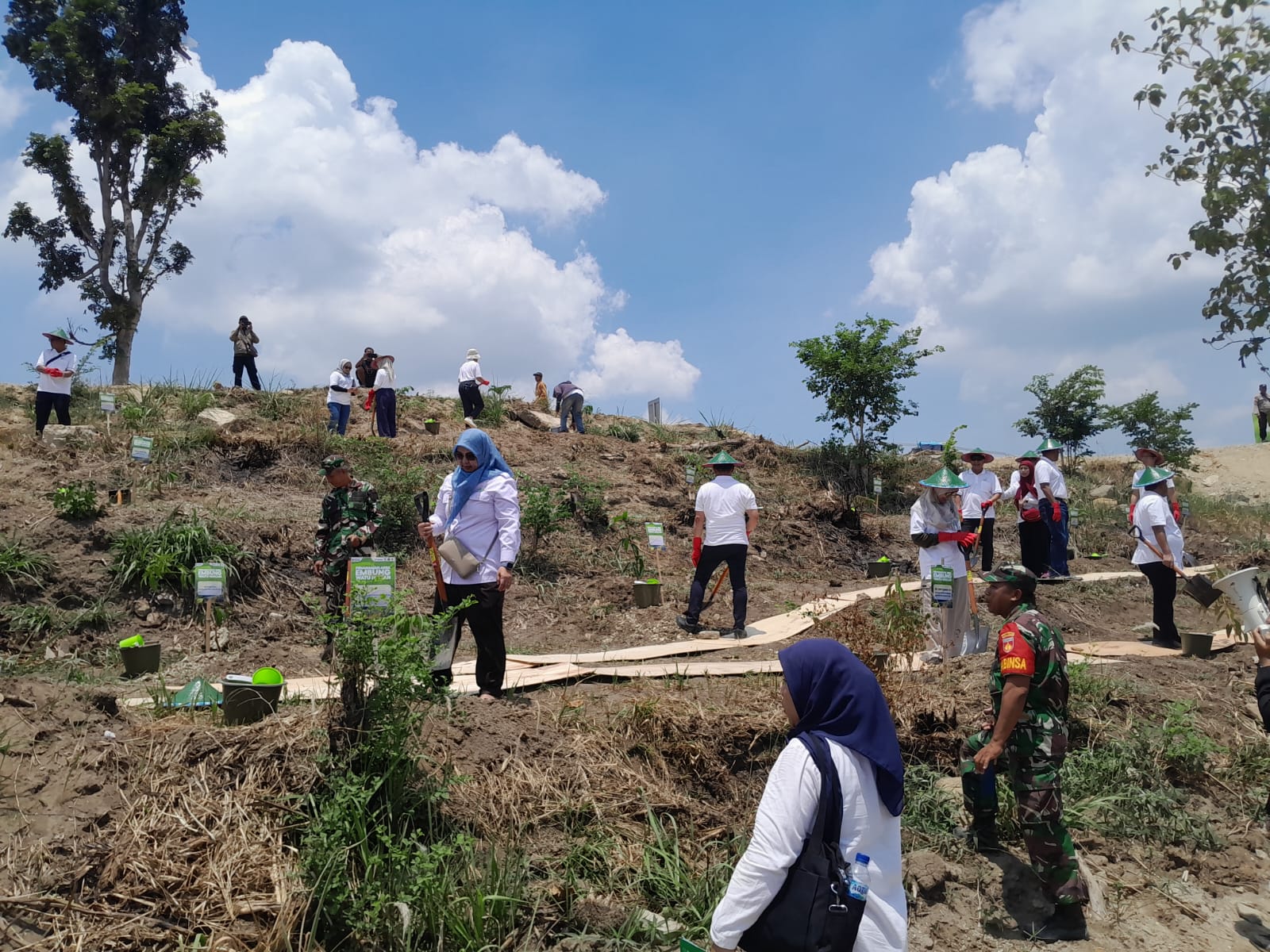 Proses penanaman bibit pohon durian dan kelengkeng oleh para tamu undangan.( foto bawah)