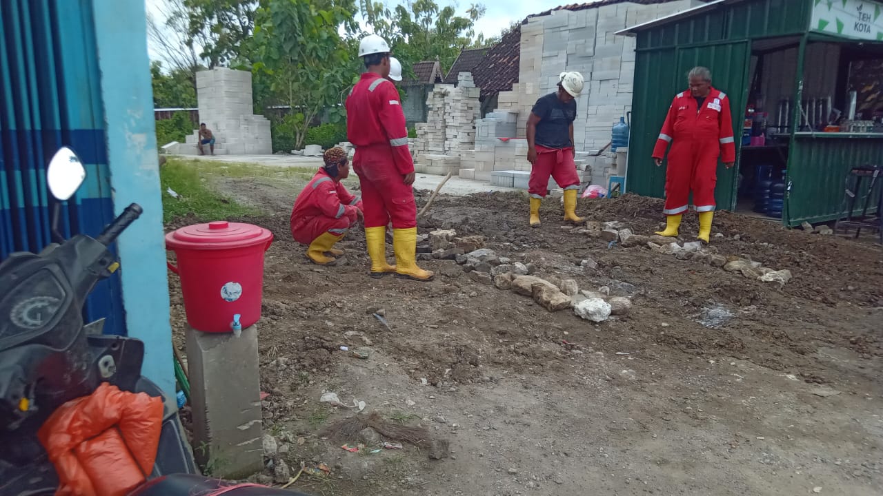 Pekerja PT EFK sedang menaruh batu dibekas galian pipa distribusi minyak milik Pertamina EP.
