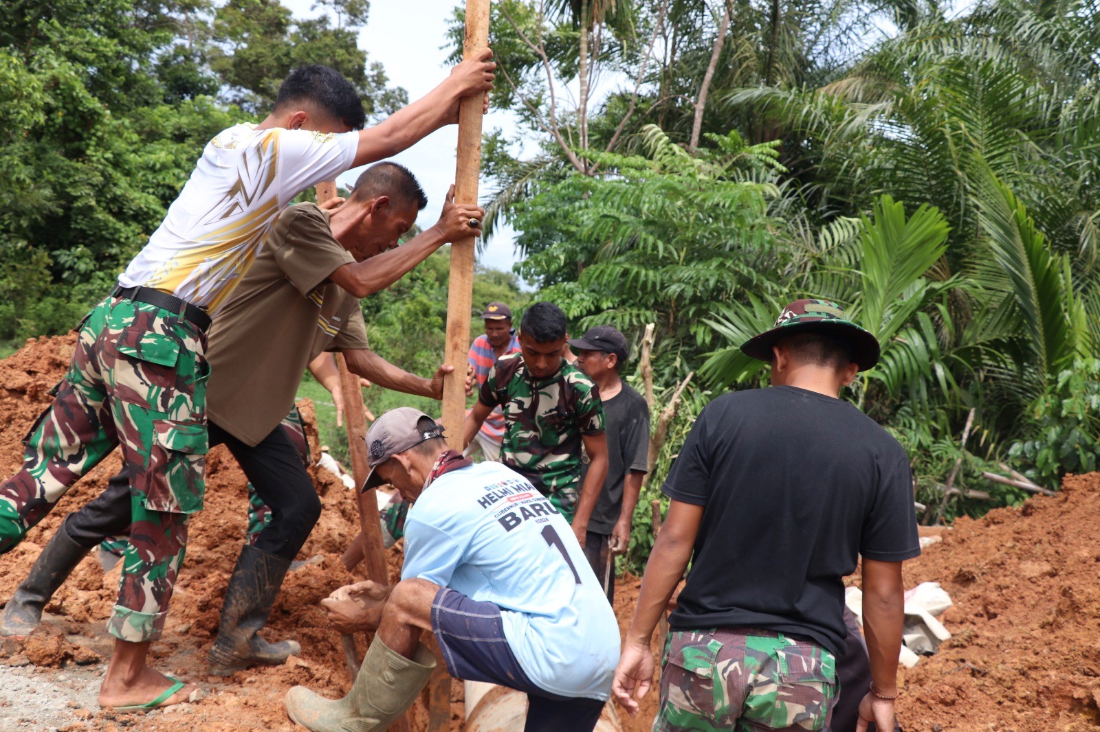gotong royong, satgas dan masyarakat berjibaku memasang gorong-gorong. Dengan kasau, gorong-gorong itu disusun presisi sesuai jalur aliran air.