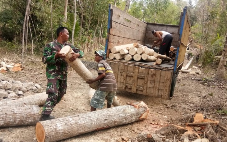 TNI dan Warga Pindahkan Batang Kayu