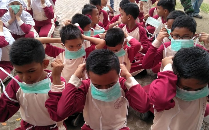 Pelajar menggunakan masker saat berolah raga pagi di lapangan Hiraq Lhokseumawe.