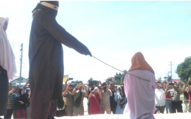 Algojo ketika menghayunkan rotan kearah punggung seorang perempuan terpidana khalwat pada awal agustus lalu di halaman Mesjid Agung Bireuen.