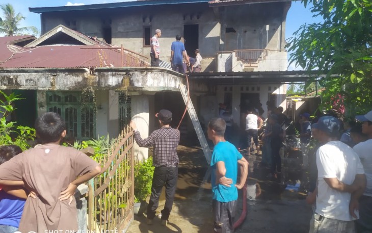 Para petugas bersama warga ketika berupaya memadamkan api yang membakar rumah pensiunan karyawan PLN di Singkil.
