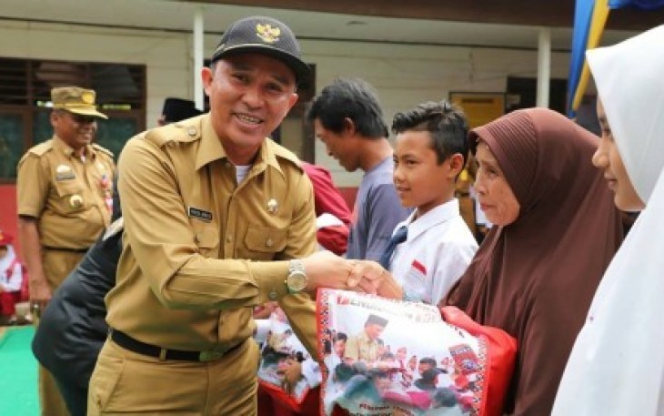 Bupati Lambar saat menyerahkan seragam gratis untuk siswa SD dan SMP