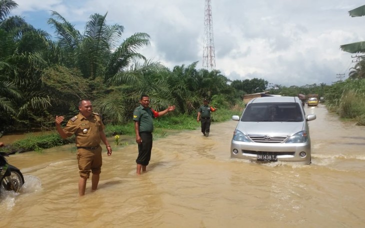 Danramil 09/NL Kapten Sofyan Sukri Bantu Warga Melintas Jalan Yang Terendam Banjir 