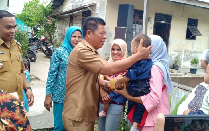 Camat Rantau Utara Turing Ritonga saat membagikan hadiah kepada ibu-ibu yang aktif membawa balitanya ke posyandu
