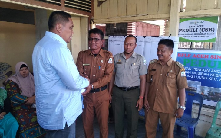 Bupati Aceh Singkil Dulmusrid saat menyerahkan bantuan korban kebakaran secara simbolis kepada Kepala Desa Ujung Singkil Jasruddin di Posko Kebakaran setempat.