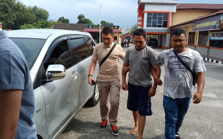 Tersangka (tengah) saat dibawa ke Mapolres Labuhanbatu