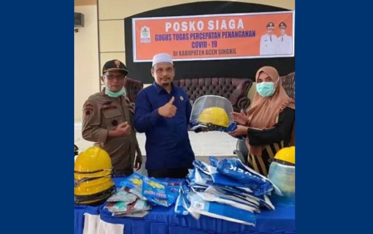 Anggota DPRK Aceh Singkil Ahmad Fadhli saat menyerahkan APD diposko siaga penanganan pencegahan virus corona setempat.