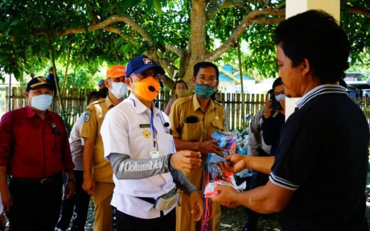 Bupati Bengkulu Selatan Gusnan Mulyadi Sedang Membagikan Masker Pada Warga 