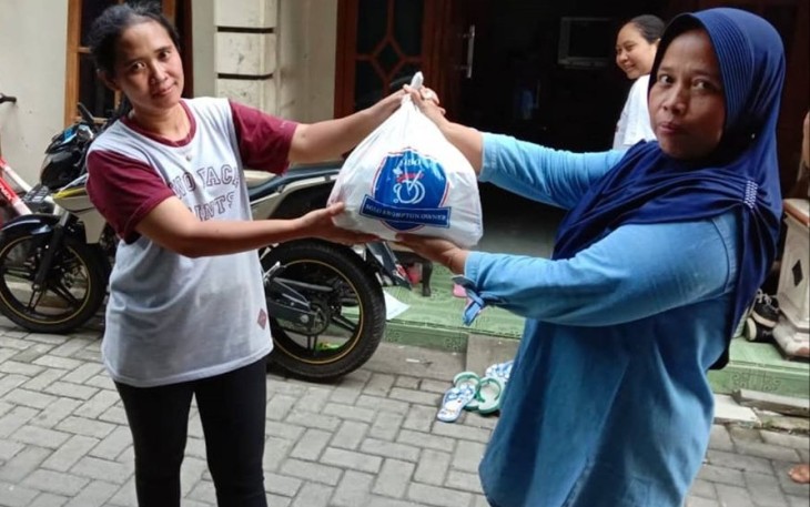 Anggota komunitas Solo Brompton Owners (SOBO) sedang membagikan paket sembako kepada warga.