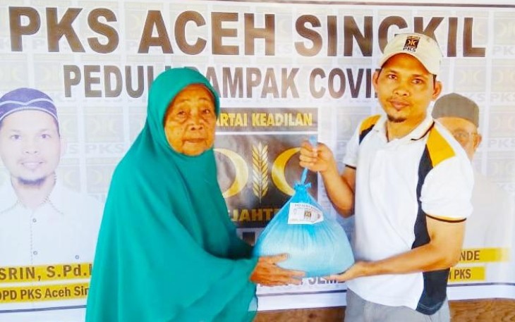 Ketua PKS Aceh Singkil Nasrin S.Pd.I menyerahkan bantuan paket sembako kepada salah seorang penerima.