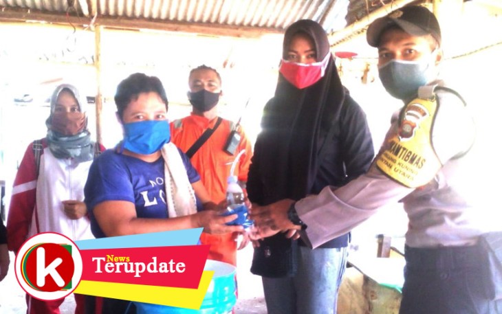 Bhabinkamtibmas saat ikut memberikan masker ke warga