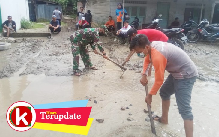 Babinsa turun langsung membuat aliran air yang menggenangi jalan