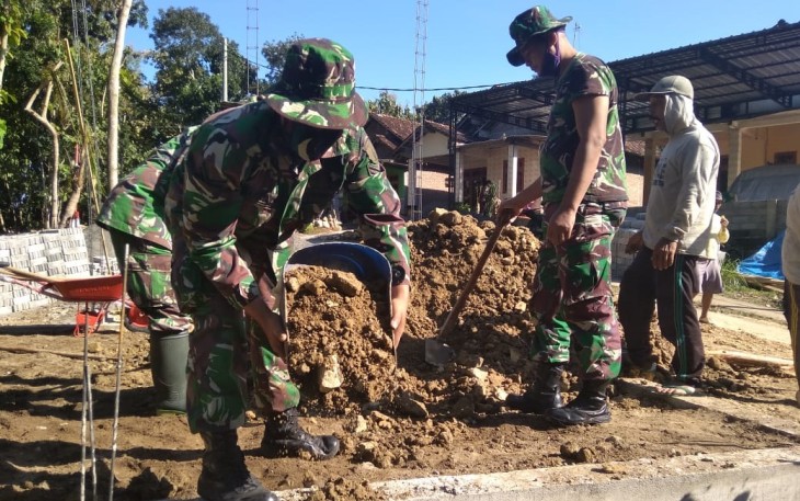 Sertu Hariyadi Lakukan Penimbunan Tanah Mushola dengan Ember di TMMD 108