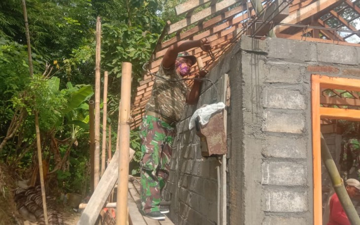 Serma Nurhadi Pasang Besi Cor atas Bangunan