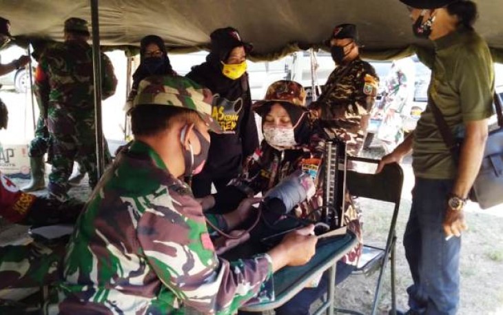 Satgas TMMD memberikan pelayanan kesehatan di posko kesehatan TMMD, Minggu 4/10/2020