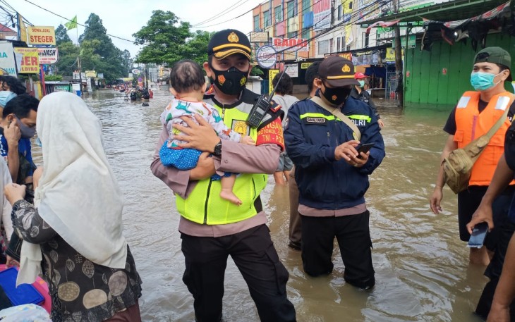 Personel Polri sedang gendong anak kecil dalam rangka evakuasi korban banjir di Jakarta