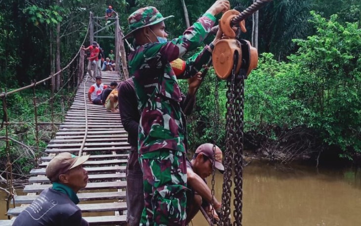 Babinsa Koramil Jila bersama warga kerja bakti perbaiki jembatan gantung 