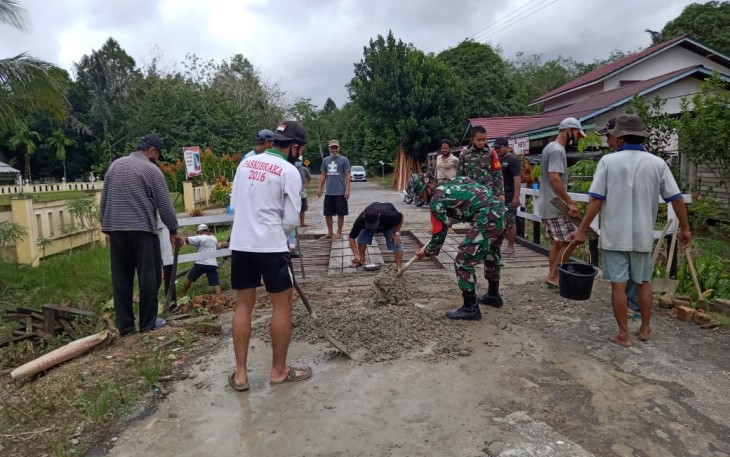 Babinsa Koramil 1206-05/Embaloh Hulu Bantu Warga Timbun Jalan Berlubang