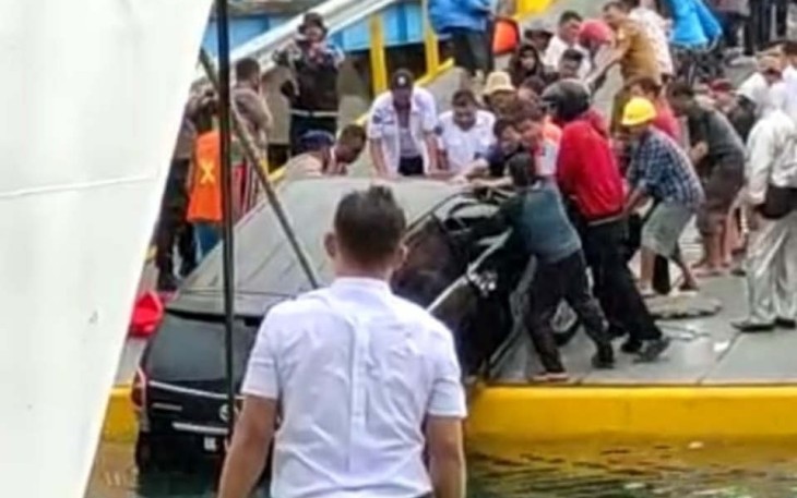 Warga bersama petugas bersama-sama mengeluarkan mobil yang jatuh ke Danau Toba