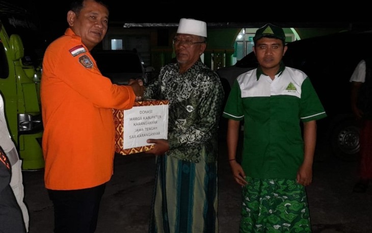 Simbolis penyerahan bantuan bagi korban erupsi Gunung Semeru oleh Prihanto selaku Dirut PUDAM Tirta Lawu sekaligus Komandan SAR Kabupaten Karanganyar kepada tokoh masyarakat setempat di posko penampungan bantuan di Desa Tamanayu, Kecamatan Pronojiwo, Kabupaten Lumajang, Jawa Timur