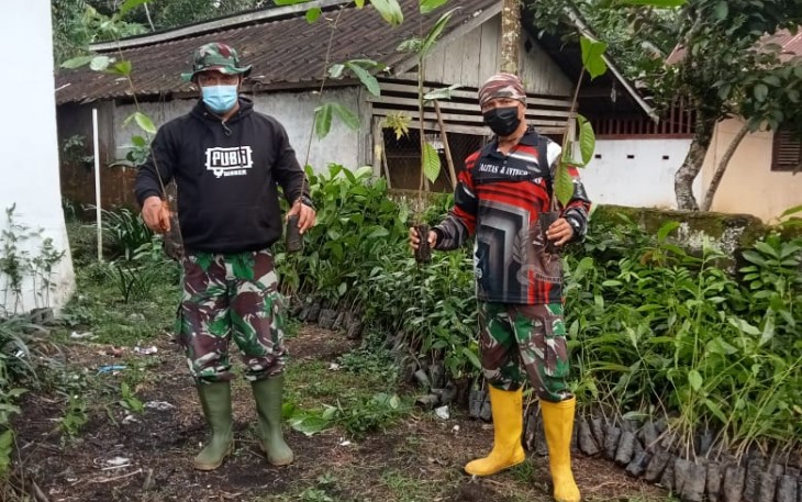 Personil Satgas TMMD Koptu Marinir Steven Dien dan Serda Marinir Anas saat mengatur bibit pohon yang akan di tanam