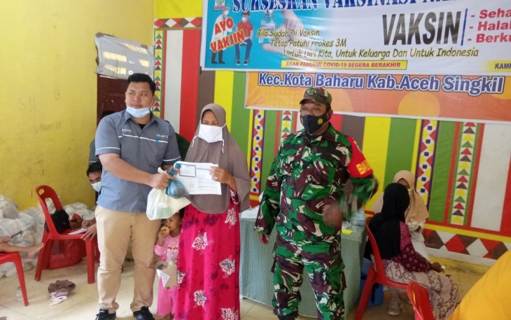 Pihak Pemdes Lentong saat memberikan bingkisan kepada warga usai mengikuti vaksinasi covid-19 didesa setempat