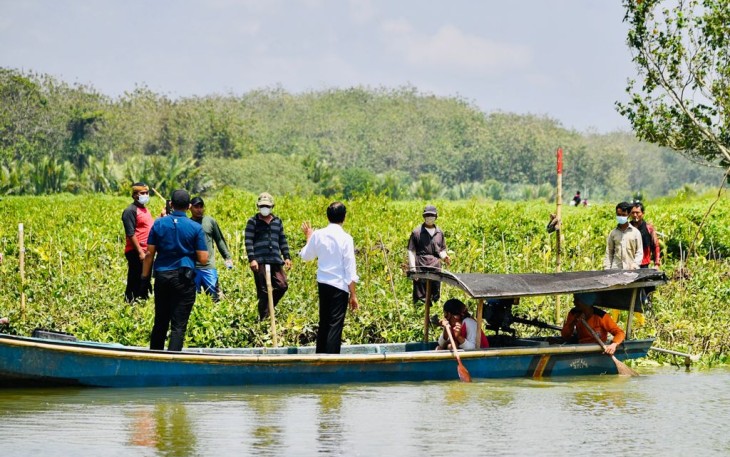 Presiden Jokowi menyempatkan diri menaiki perahu rakyat untuk menyeberangi sungai demi menyapa warga secara langsung yang ada di seberang sungai