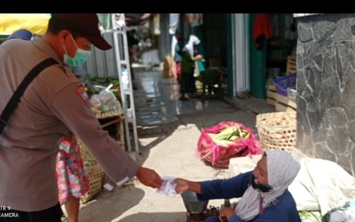Anggota Polsek Brangsong sedang membagikan masker gratis kepada pedagang di Pasar Sidorejo Brangsong