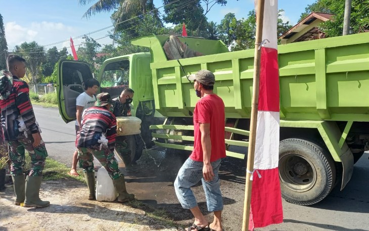 Personil satgas TMMD bantu sopir Dum Truk padamkan api yang keluar dari aki