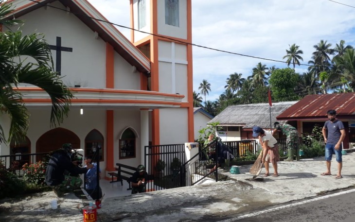 Warga bersama satgas TMMD kodim Bitung melakukan pembersihan area gereja katolik