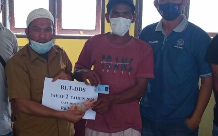Pj Kepala Desa Kayu Menang, Salihin,A.Md saat menyerahkan BLT-DD kepada keluarga penerima manfaat