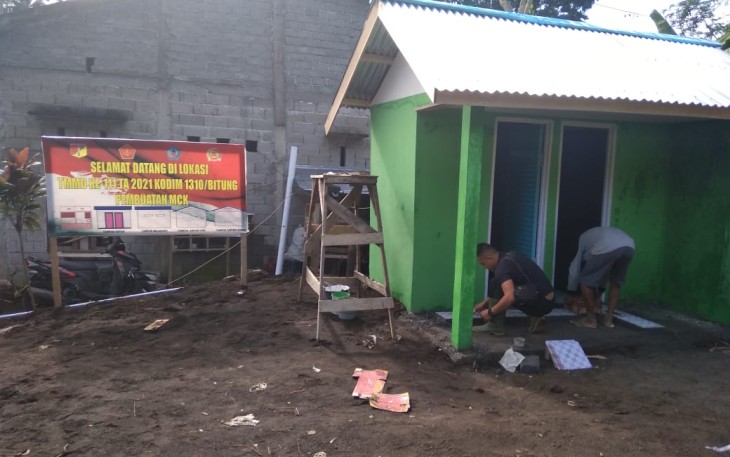 Satgas TMMD saat memasang teghel dan instalasi pipa