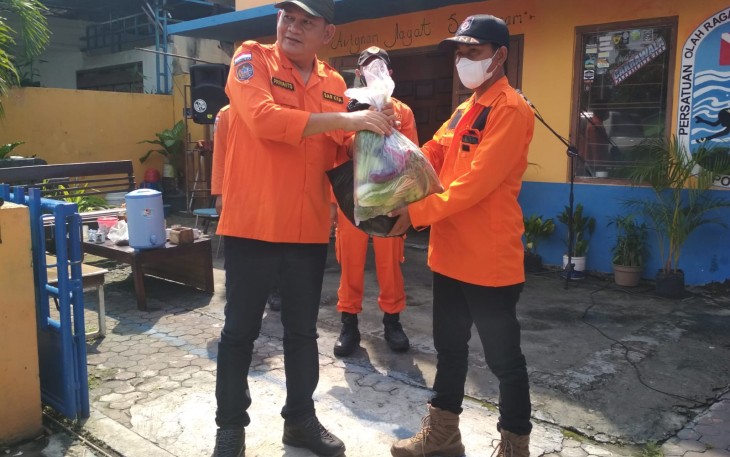 Komandan SAR Kabupaten Karanganyar, Prihanto (kiri), secara simbolis menyerahkan sumbangan paket sembako kepada perwakilan anggota relawan untuk didistribusikan kepada warga terdampak pandemi Covid-19.