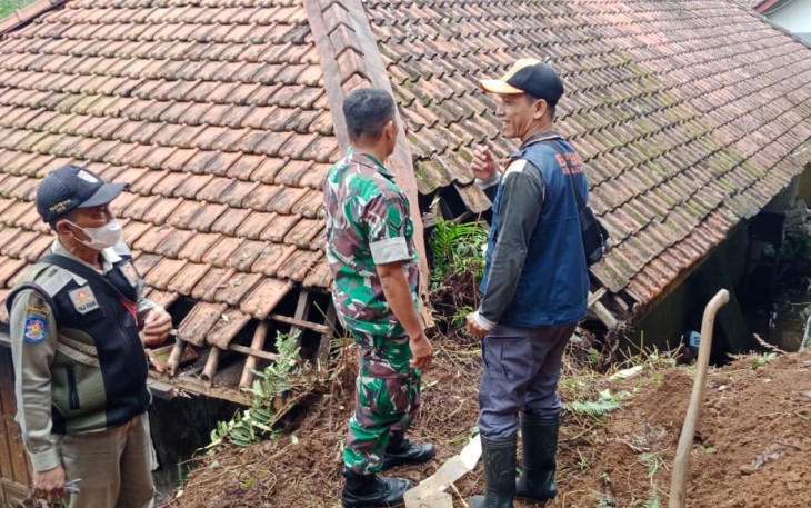 Petugas saat mengecek lokasi longsor terjang salah satu rumah warga.