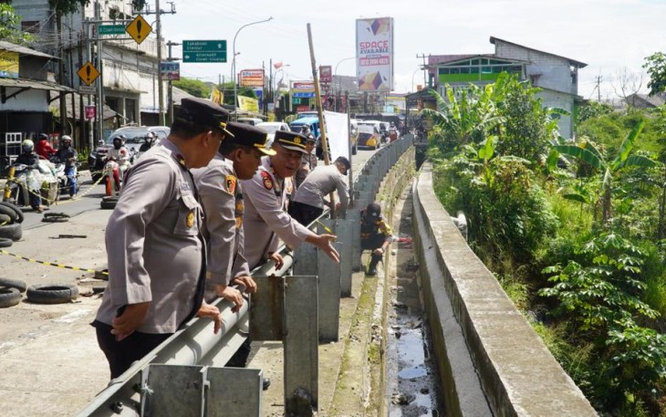 Polres Bogor saat memberi garis polisi disekitar jalan rawan longsor
