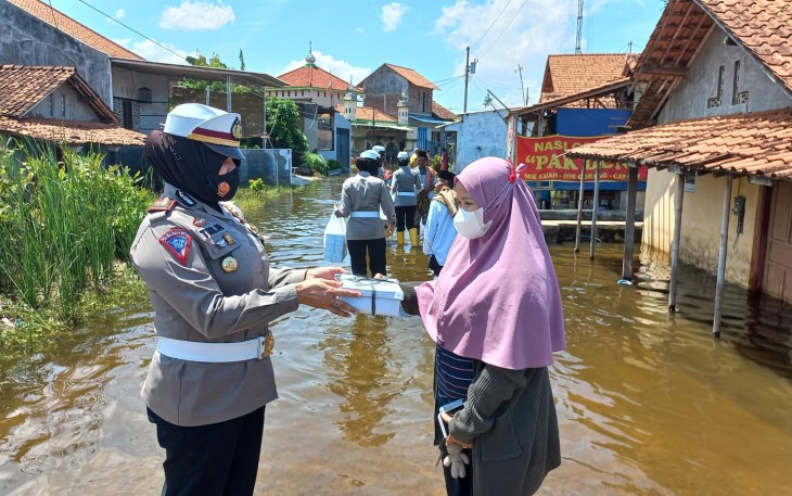 Personel Polres Pekalongan Kota membagikan nasi kotak kepada masyarakat terdampak banjir di Desa Karangjompo