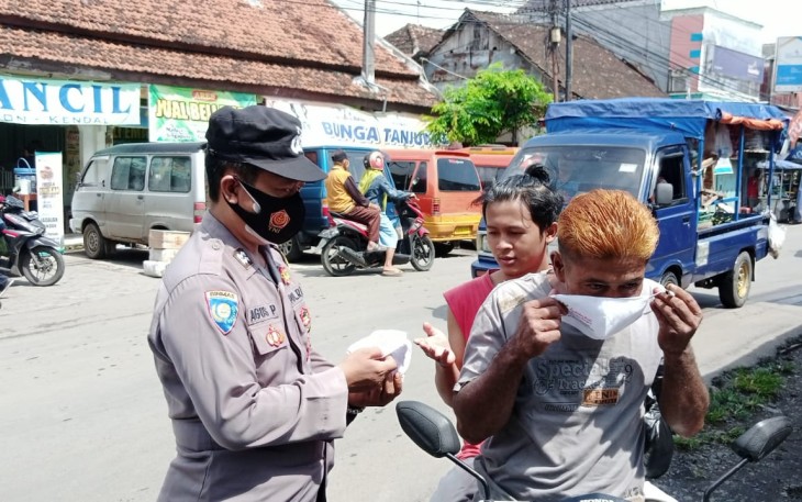 Kapolsek Pegandon, AKP Zainal Arifin beserta anggota saat berbagi masker di Pasar Pegandon