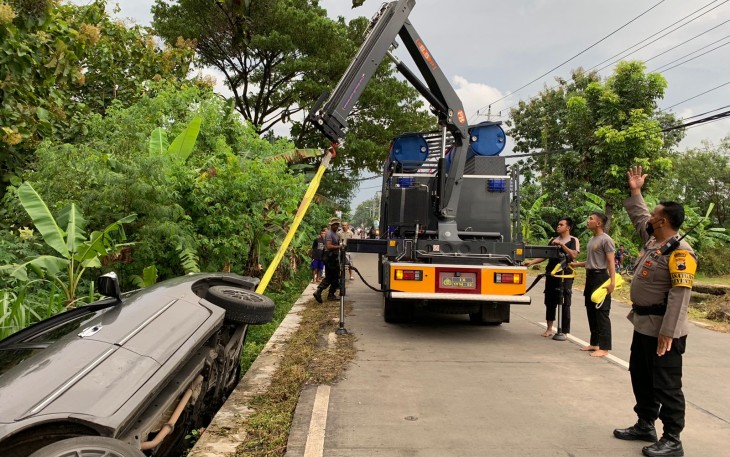 Tim SAR Samapta Polres Karanganyar, saat melakukan evakuasi mobil yang terperosok ke dalam selokan