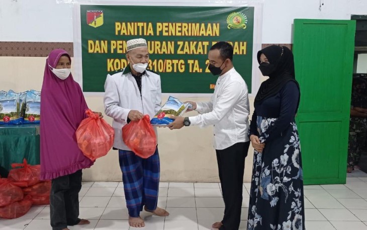Dandim 1310/Bitung didampingi ketua persit, saat pembagian zakat fitrah, Jumat (29/4/2022)