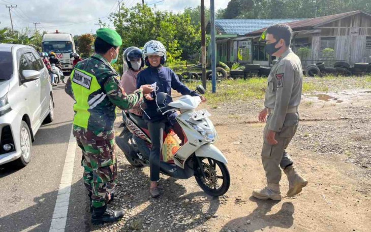 Sertu Kardianto bagikan masker ke pengendara jalan. Senin (09/05/2022)