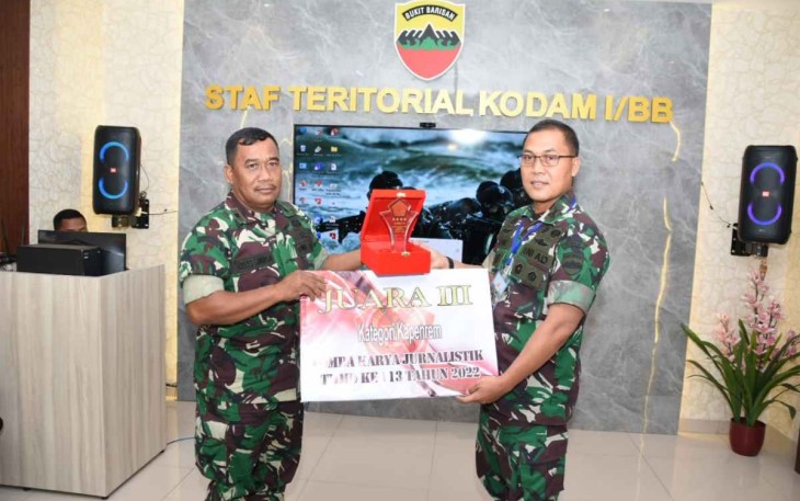 Kapenrem 023/KS Mayor Arh Keles Sinaga (kiri) saat menerima piagam juara ke tiga LKJ TMMD Ke 113 Kodim 0205/TK TA.2022 