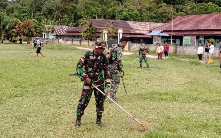 Satgas perbatasan potong rumput lapangan sepak bola