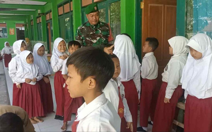 Sertu Istamar saat mendampingi imunisasi anak sekolah