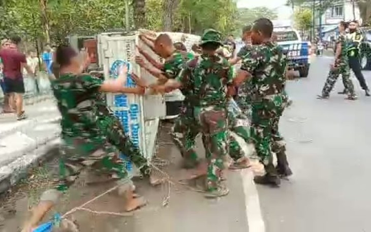 Evakuasi mobil warga  terguling dibantu prajurit Alugoro
