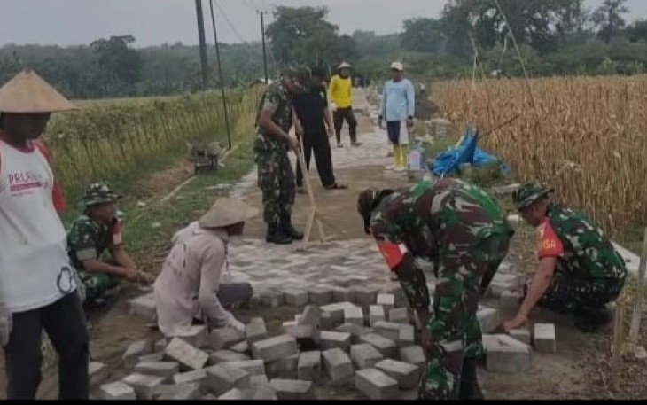 Pemasangan paving jalan desa binaan