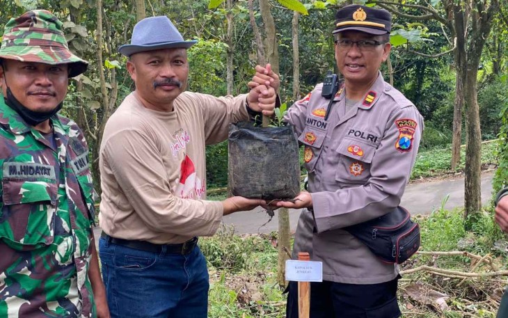 Kapolsek Junrejo Iptu Anton Hendri saat pelaksanaan tanam pohon mangga dan alpukat di desa Tlekung Kota Batu, Minggu (4/12)